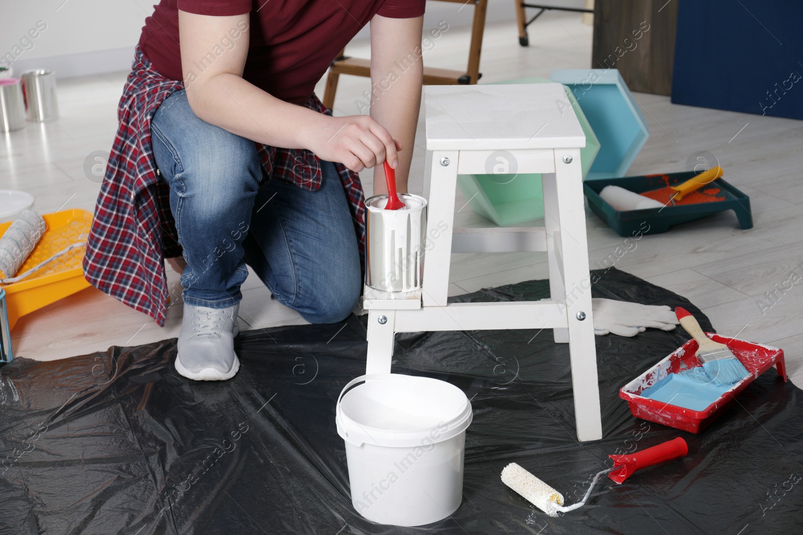 Photo of Man using brush to paint bekvam with white dye indoors, closeup