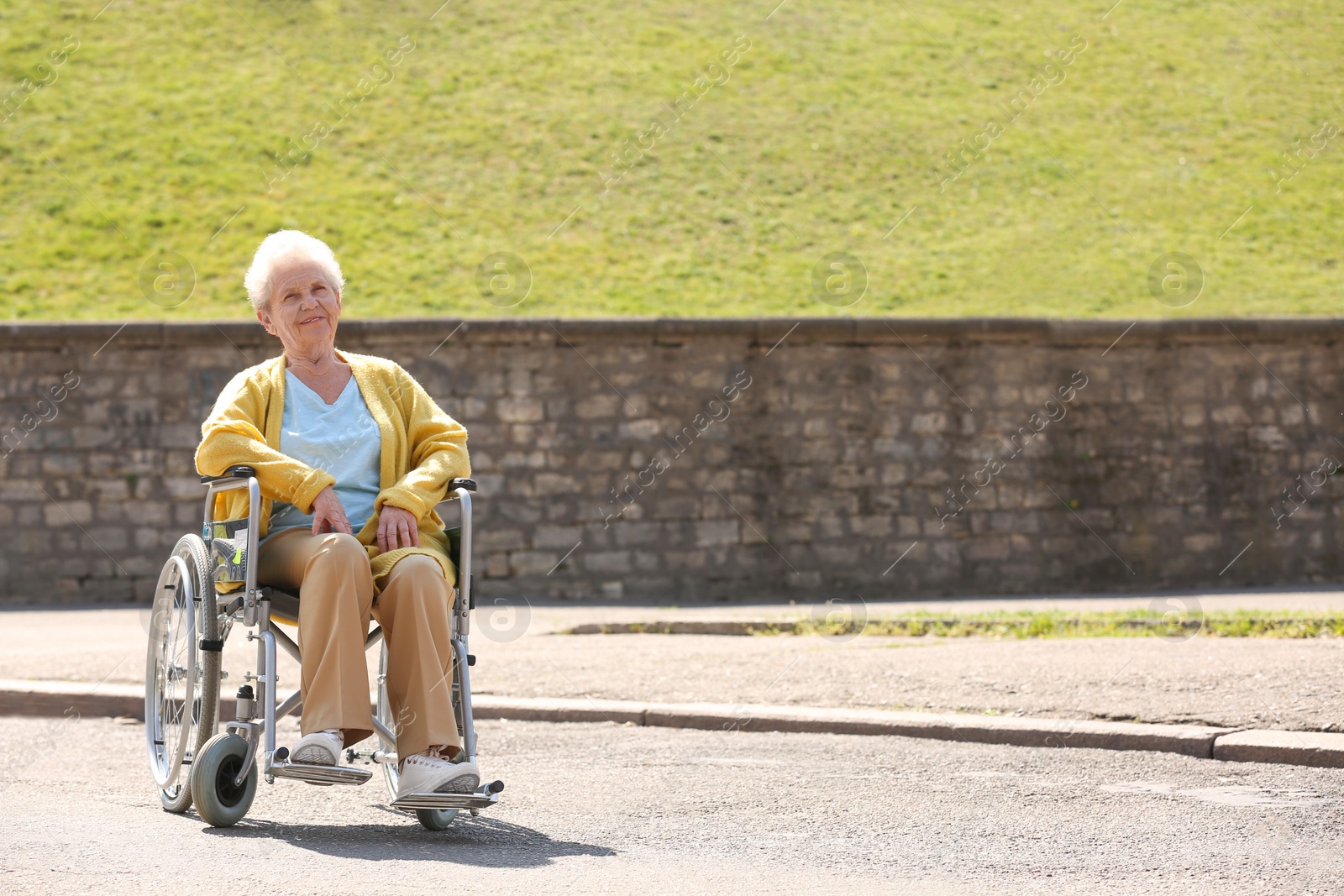 Photo of Senior woman in wheelchair at park on sunny day