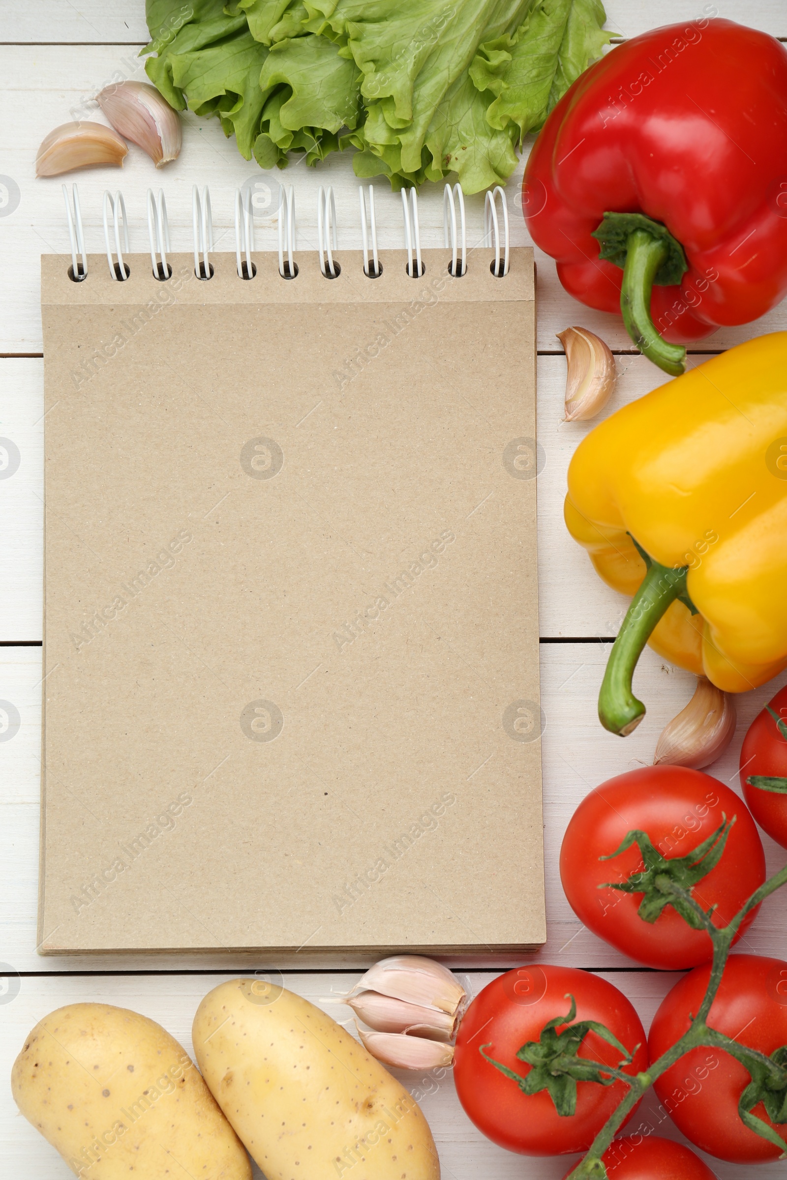 Photo of Blank recipe book and different ingredients on white wooden table, flat lay. Space for text