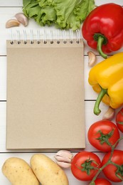 Blank recipe book and different ingredients on white wooden table, flat lay. Space for text