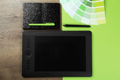 Photo of Flat lay composition with graphic tablet, notebook and color palette on table, space for text. Designer's workplace