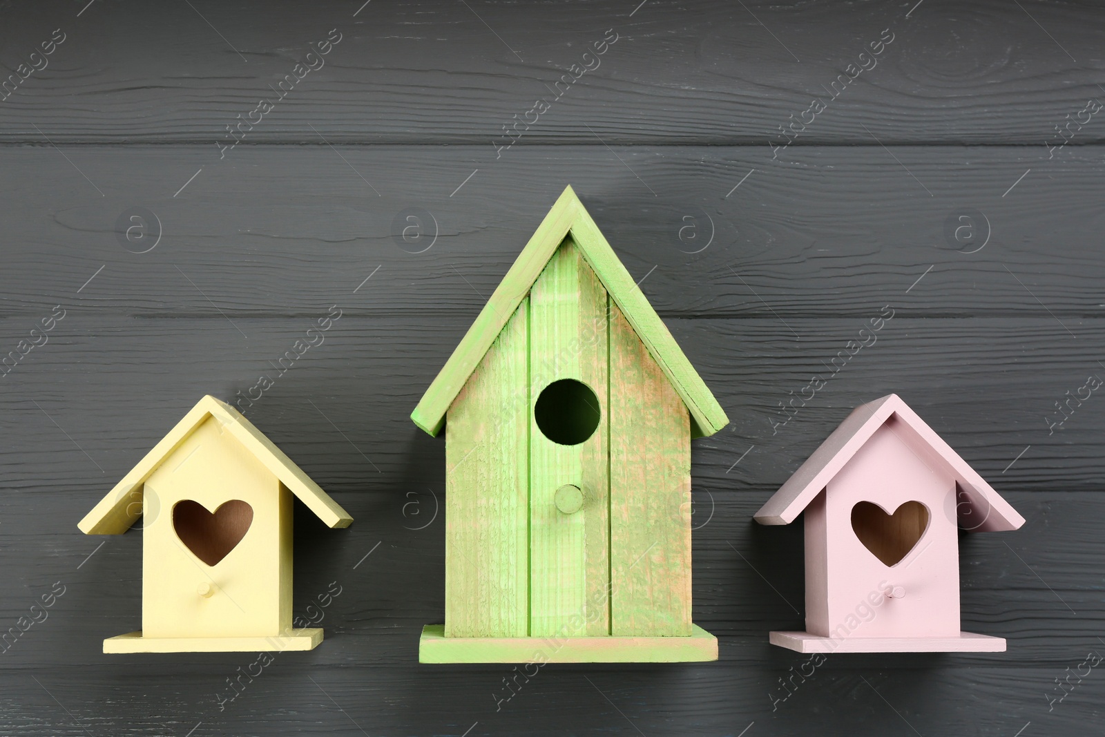 Photo of Beautiful bird houses on grey wooden table, flat lay