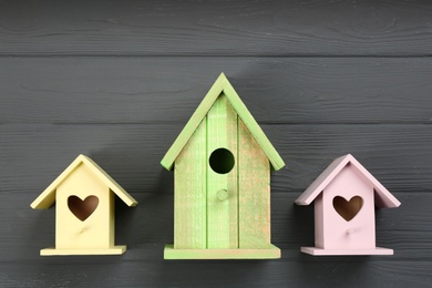 Beautiful bird houses on grey wooden table, flat lay