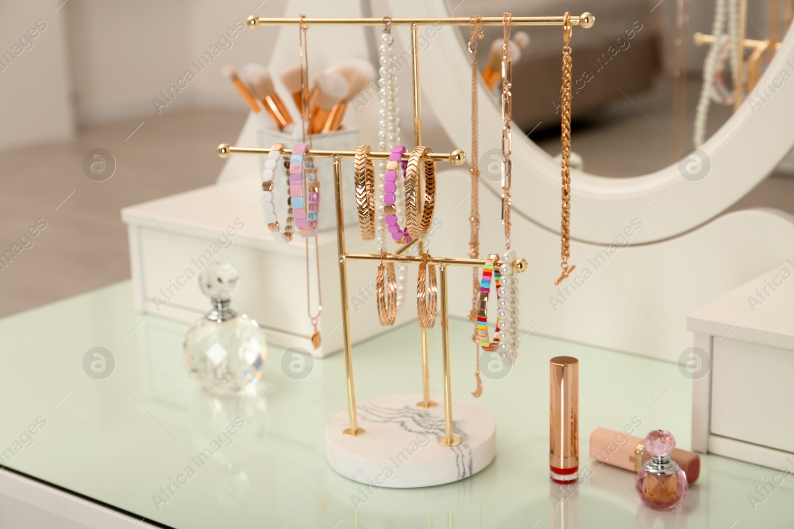 Photo of Holder with set of luxurious jewelry on white dressing table