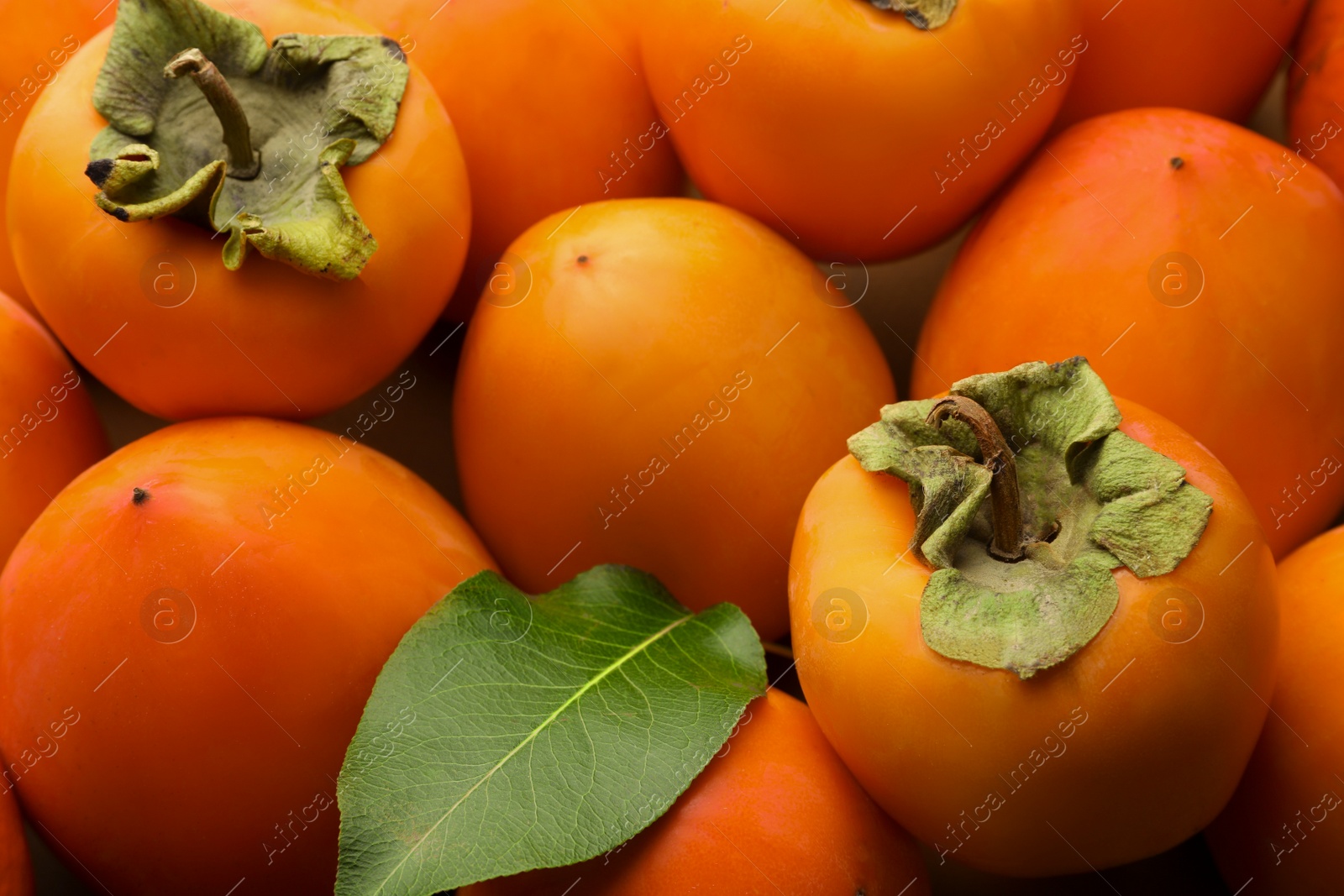 Photo of Pile of delicious ripe juicy persimmons as background, closeup