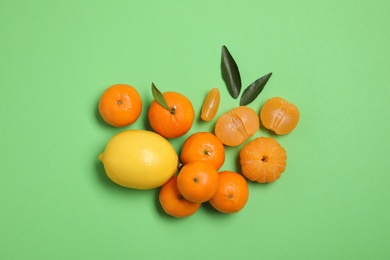 Photo of Different citrus fruits on green background, flat lay