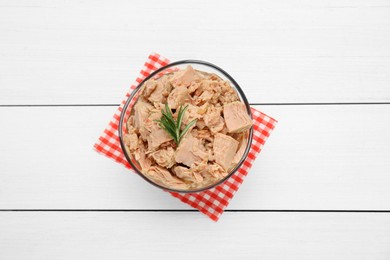 Bowl with canned tuna and rosemary on white wooden table, top view