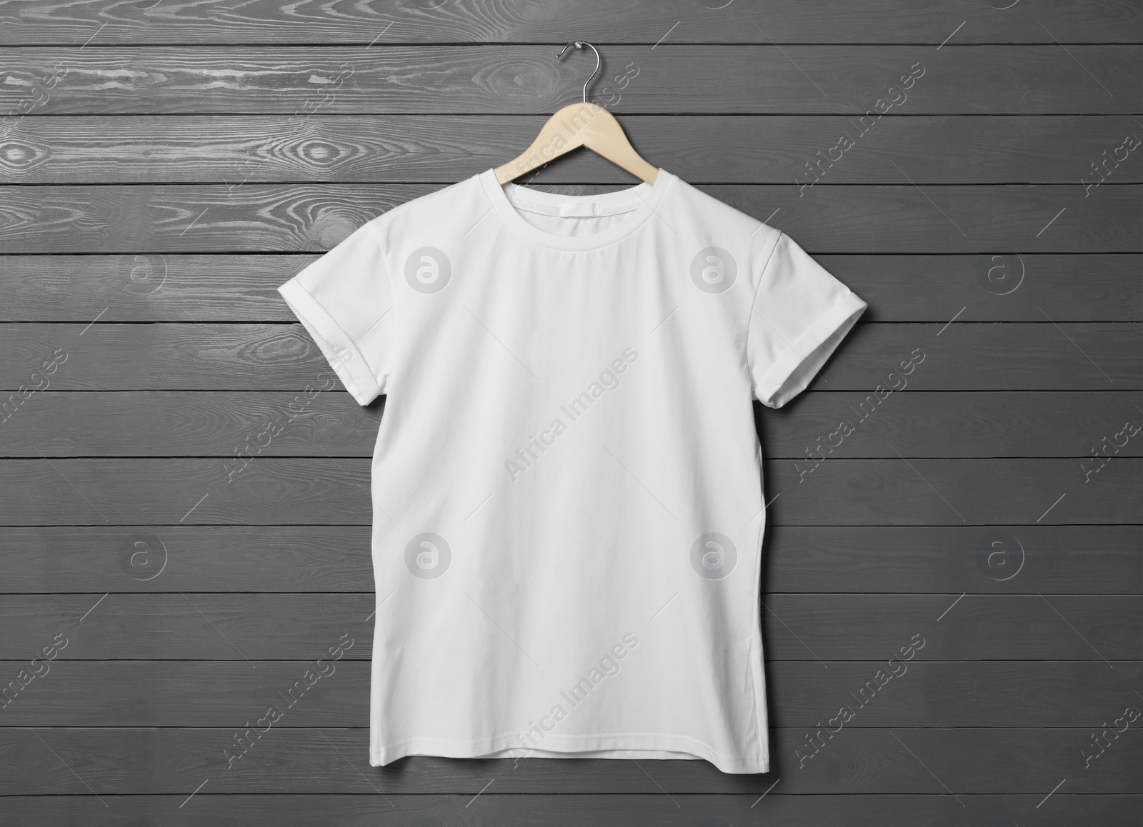 Photo of Hanger with stylish white T-shirt on gray wooden wall