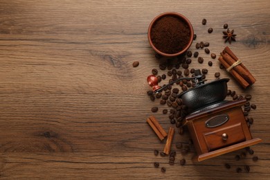 Vintage manual coffee grinder with beans and powder on wooden table, flat lay. Space for text