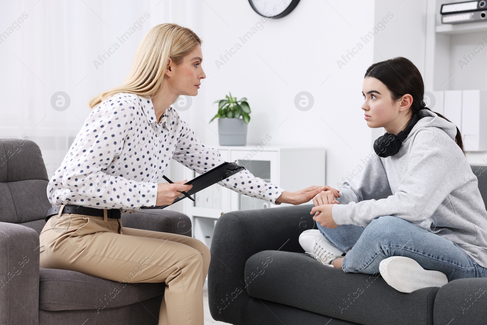 Photo of Psychologist working with teenage girl in office