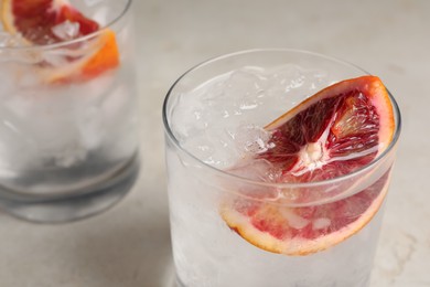 Photo of Delicious refreshing drink with sicilian orange and ice cubes on light table, closeup