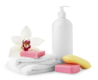 Different soap bars, bottle dispenser and terry towels on white background