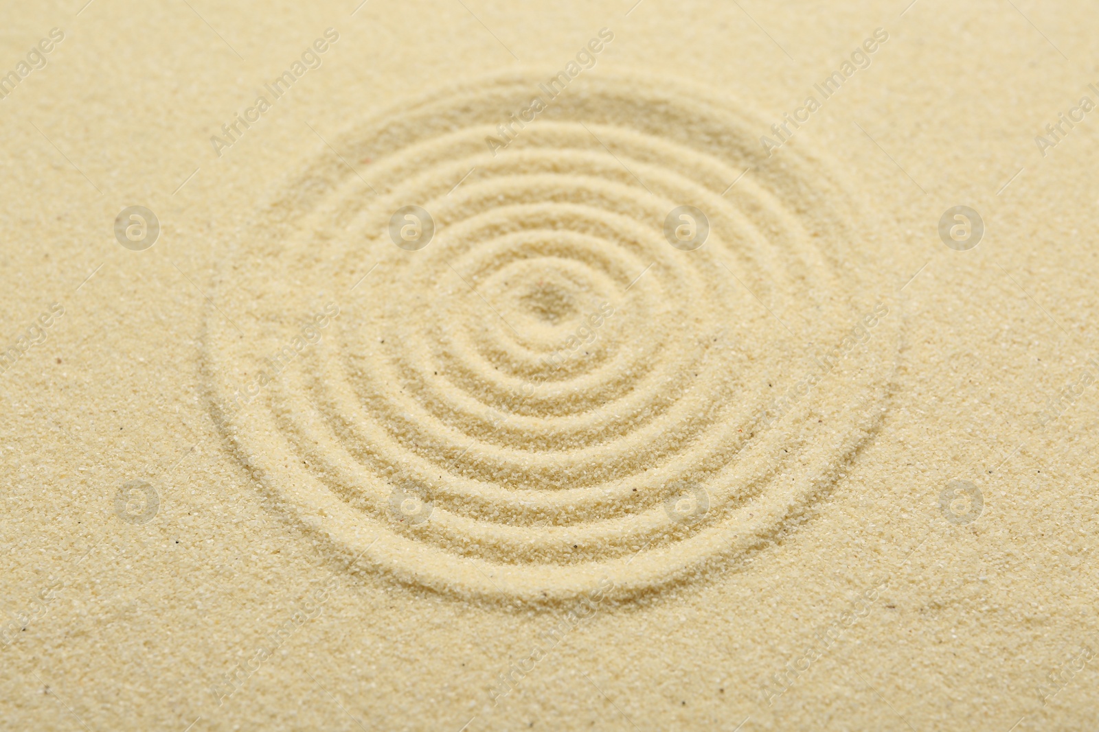 Photo of Zen rock garden. Circle pattern on beige sand