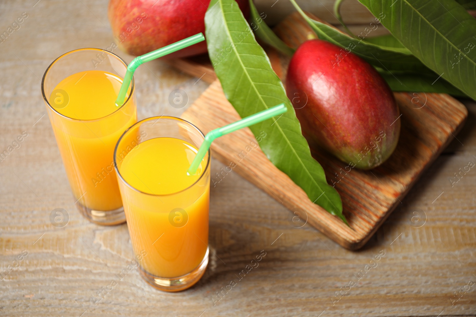 Photo of Fresh delicious mango drink on wooden table