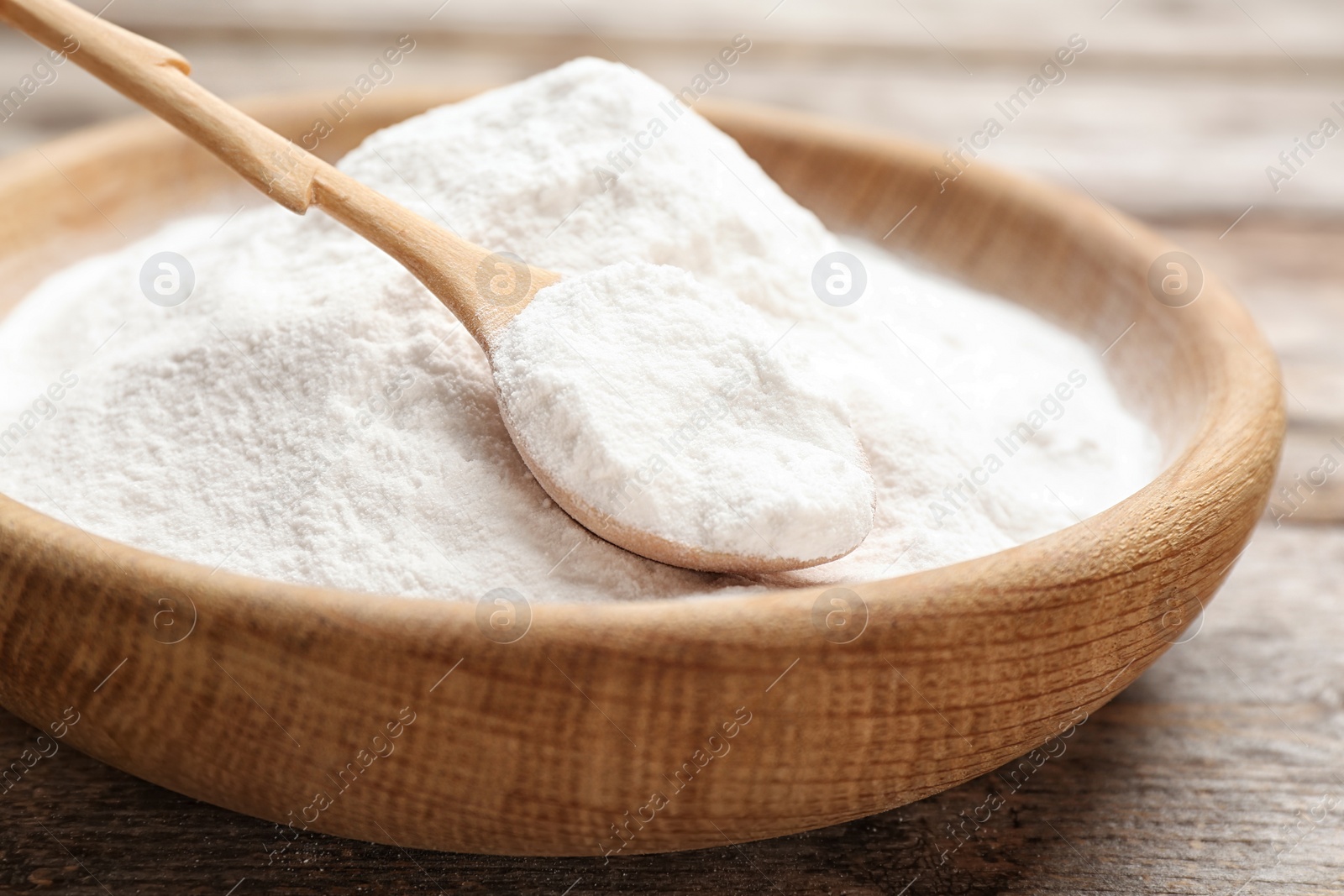 Photo of Plate with baking soda on wooden table, closeup