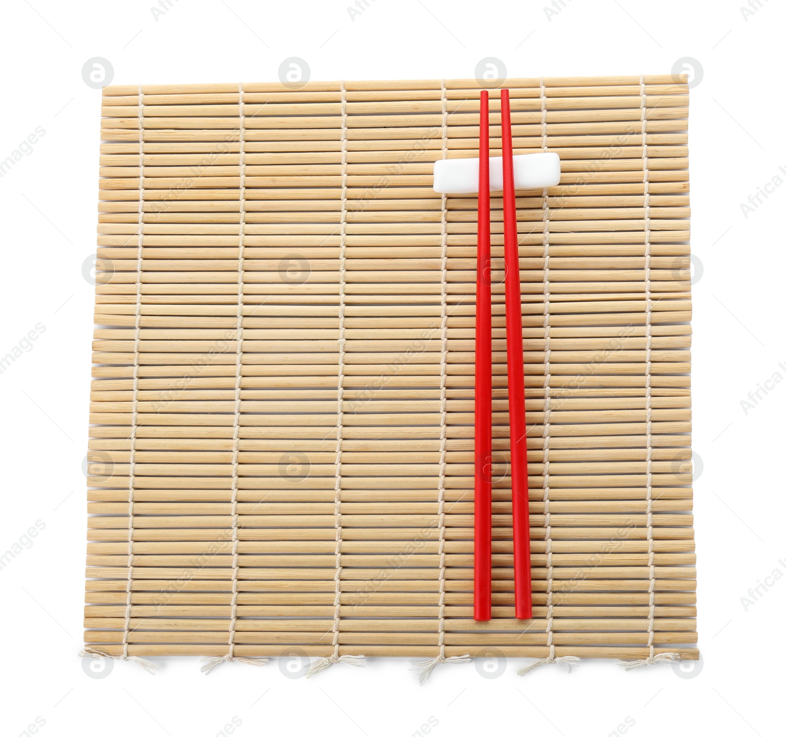 Photo of Bamboo mat with pair of red chopsticks and rest isolated on white, top view