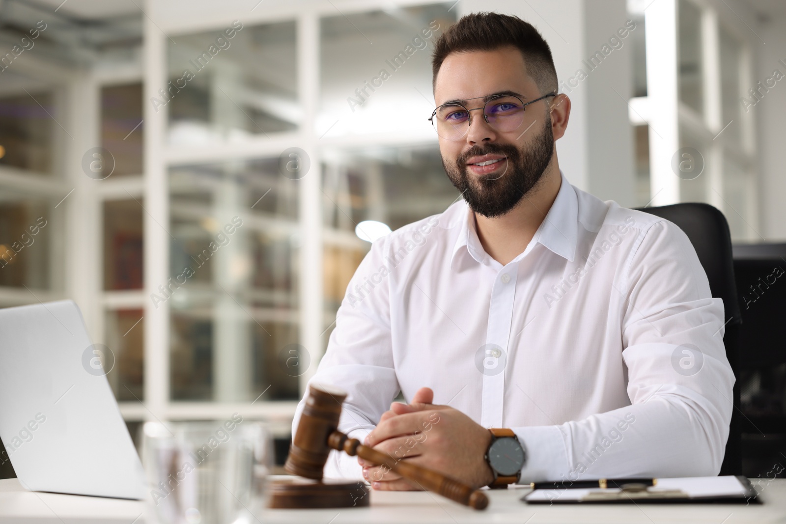 Photo of Portrait of smiling lawyer at table in office