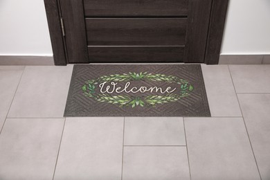 Photo of Beautiful doormat with word Welcome on floor near entrance