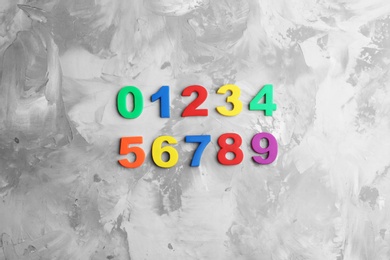 Colorful magnetic numbers on grey  background, flat lay