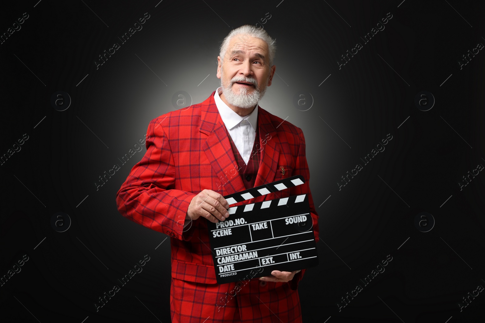 Photo of Senior actor with clapperboard on black background. Film industry