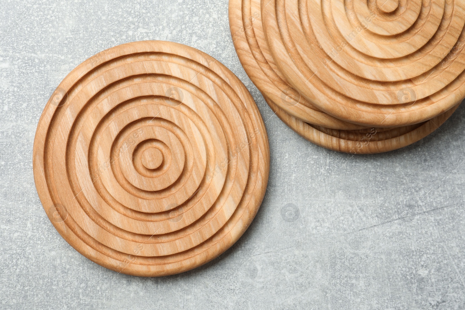 Photo of Stylish wooden cup coasters on light grey table, flat lay