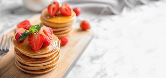 Tasty pancakes with berries on wooden board, space for text. Banner design