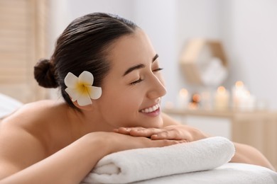 Photo of Beautiful woman relaxing on massage couch in spa salon, space for text