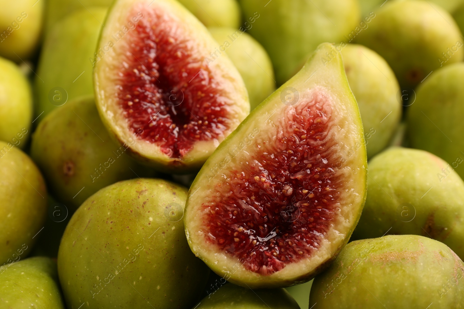 Photo of Halves of green fig on fresh fruits, closeup
