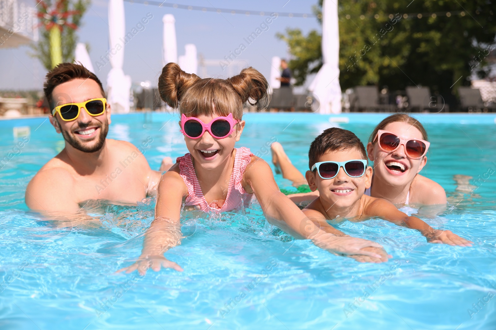 Photo of Happy family having fun in swimming pool