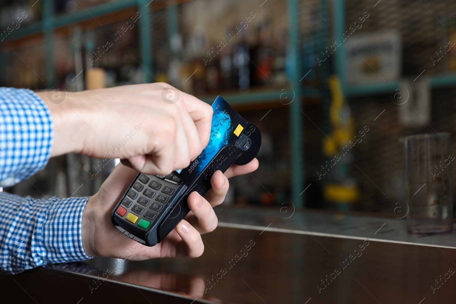 Photo of Man using credit card machine for non cash payment in cafe, closeup. Space for text