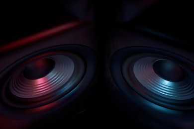 Modern sound speakers in neon light as background, closeup
