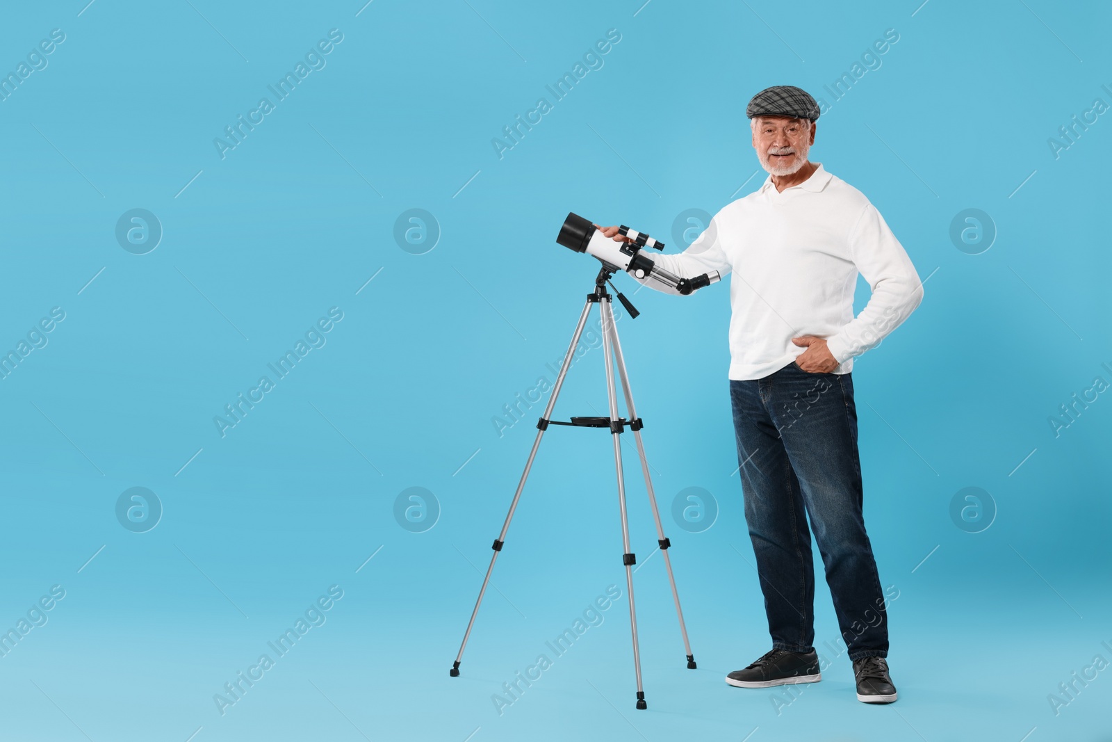 Photo of Senior astronomer with telescope on light blue background Space for text