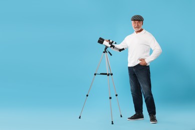 Photo of Senior astronomer with telescope on light blue background Space for text