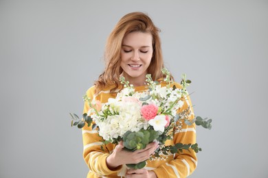 Photo of Beautiful woman with bouquet of flowers on grey background