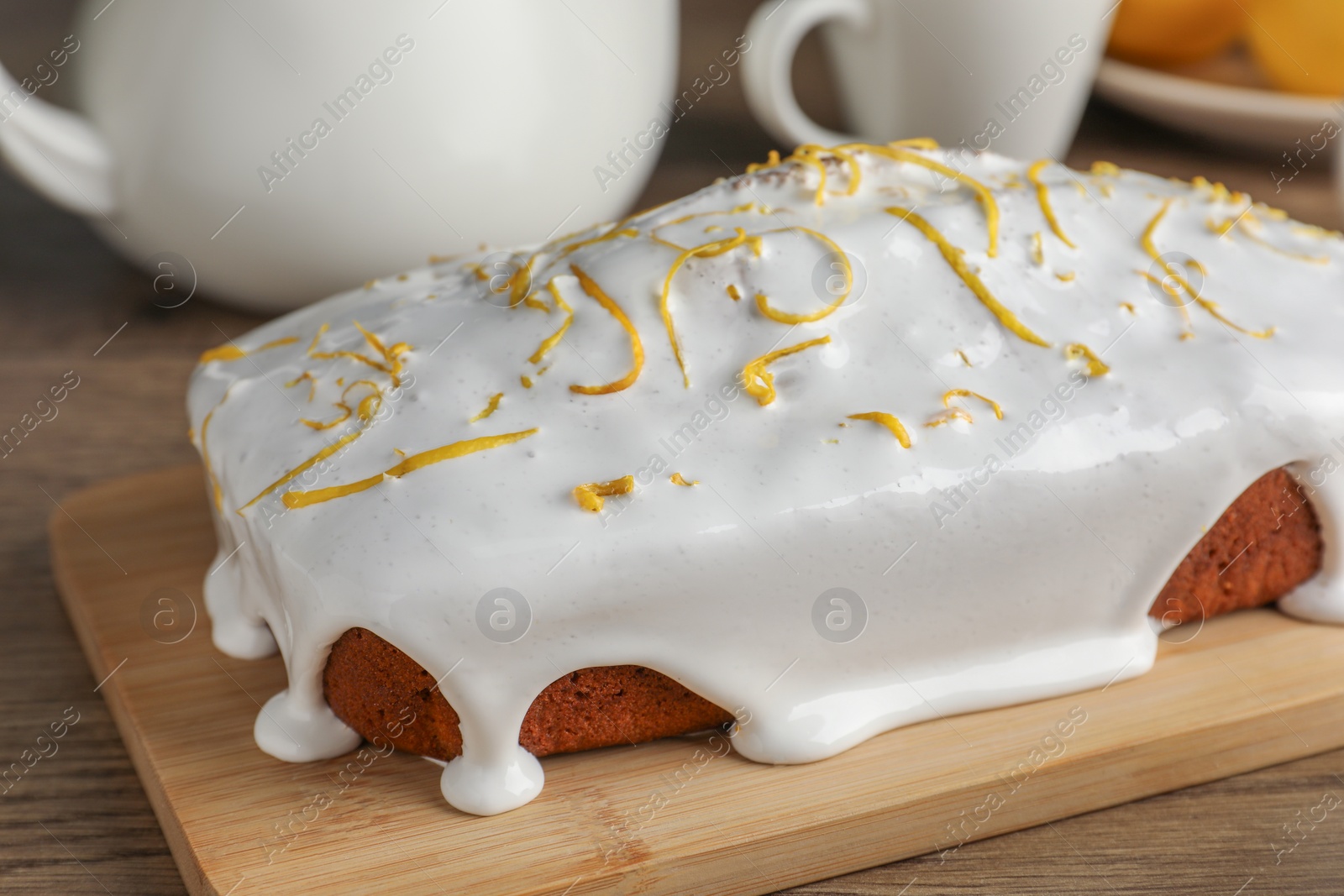 Photo of Tasty lemon cake with glaze on wooden table, closeup