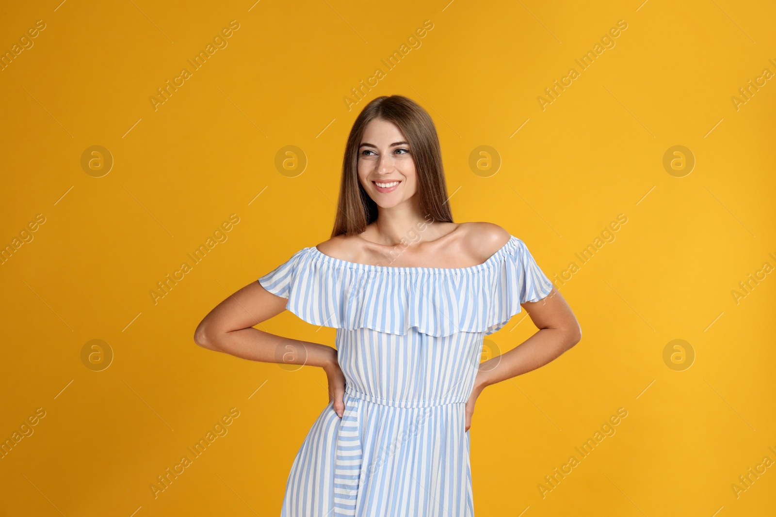 Photo of Young woman wearing stylish dress on yellow background