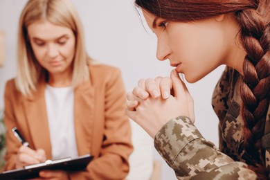 Photo of Psychologist working with military officer indoors, closeup