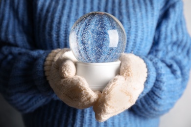 Photo of Woman holding magical empty snow globe, closeup