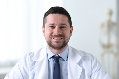 Photo of Portrait of smiling doctor on blurred background