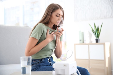 Photo of Young woman with asthma machine in light room