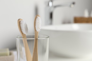 Photo of Bamboo toothbrushes on blurred background, closeup. Space for text