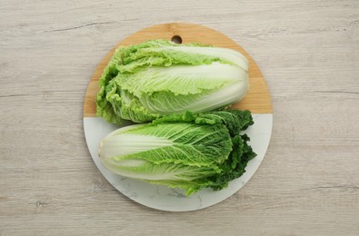 Photo of Fresh ripe Chinese cabbages on white wooden table, top view