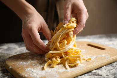 Photo of Woman preparing pasta at table, closeup view