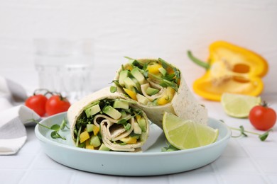 Photo of Delicious sandwich wraps with fresh vegetables and slice of lime on white tiled table