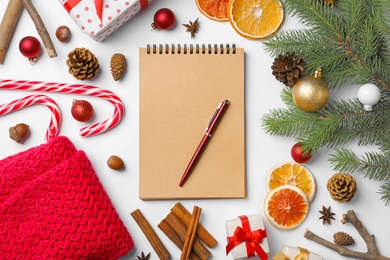 Photo of Flat lay composition with notebook and Christmas decor on white background. Letter for Santa Claus