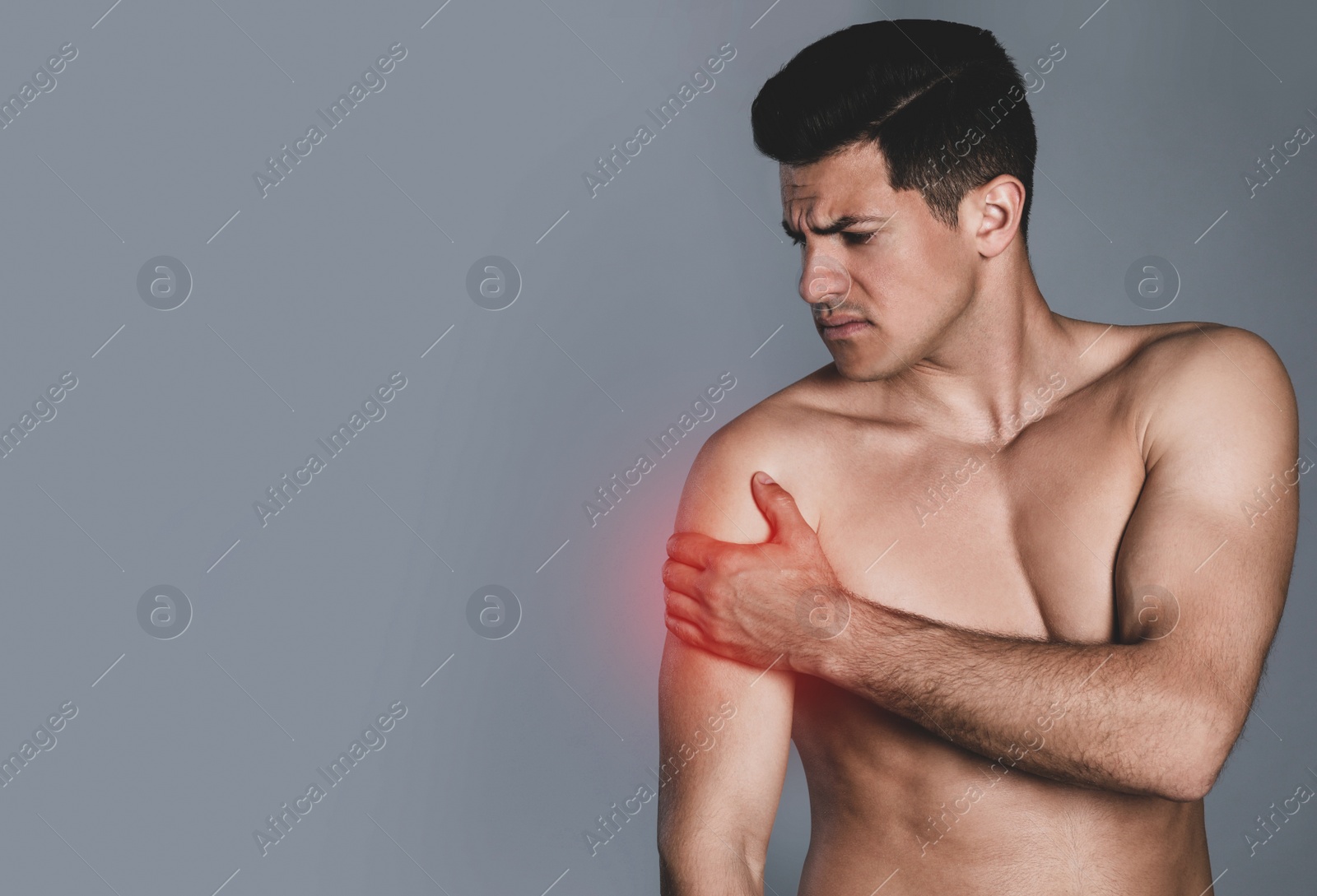 Image of Man suffering from shoulder pain on grey background. Space for text
