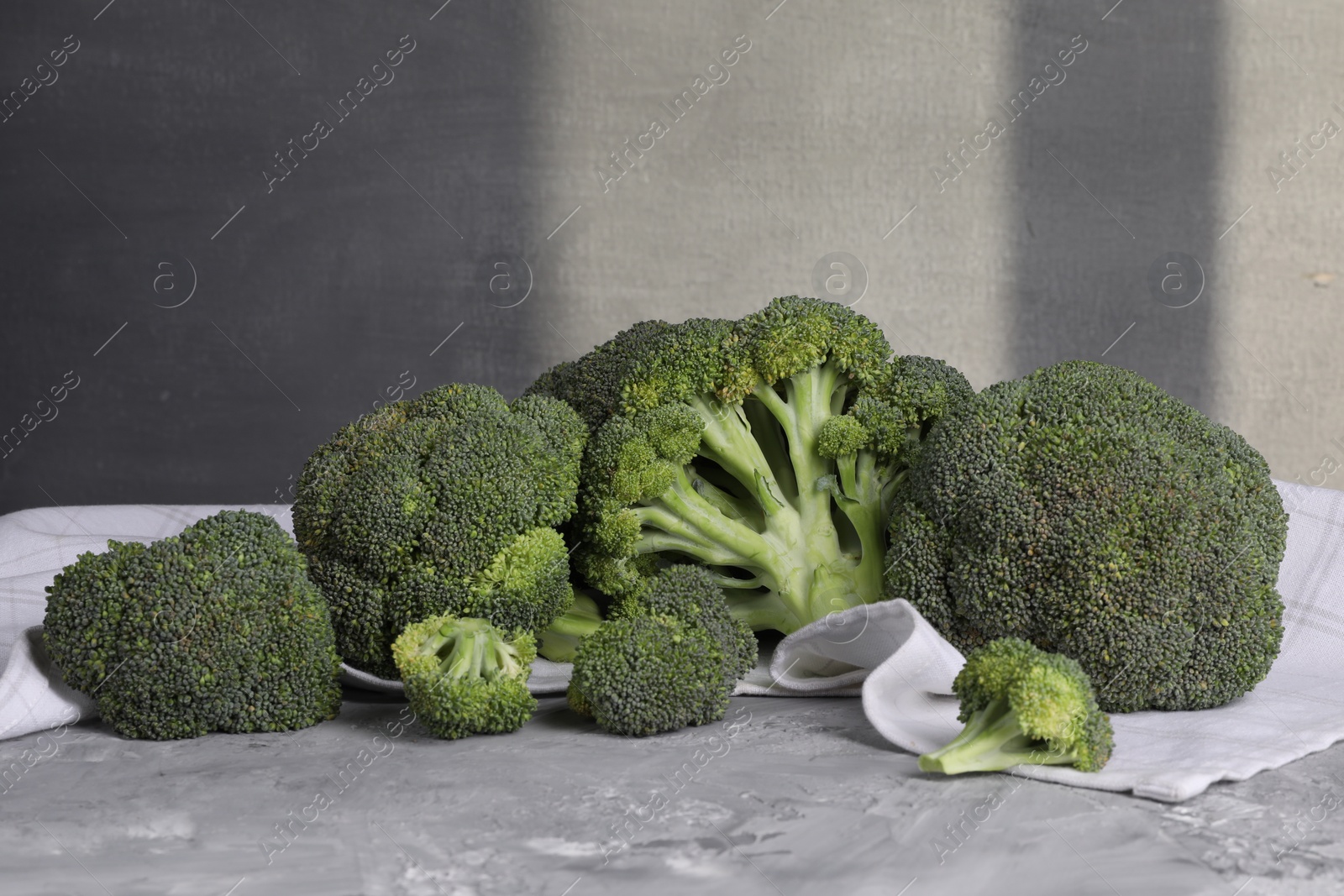 Photo of Fresh raw broccoli on grey textured table