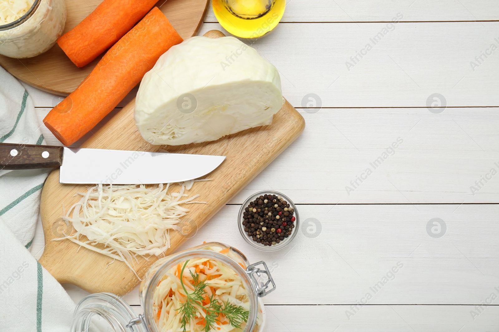 Photo of Cooking delicious sauerkraut soup. Fresh chopped cabbage and ingredients on white wooden table, flat lay. Space for text