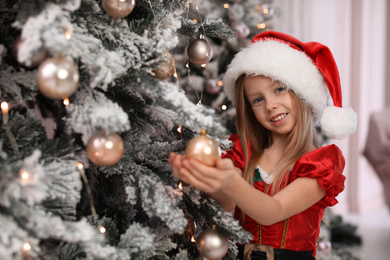 Cute little child near Christmas tree at home