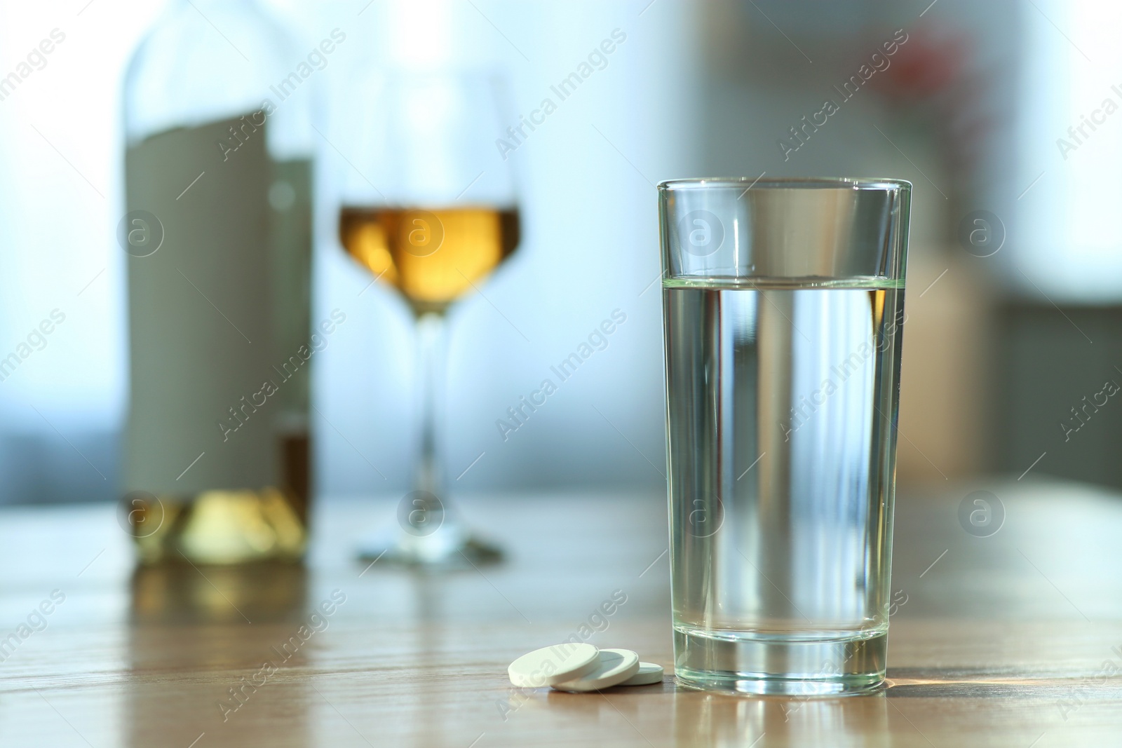 Photo of Glass of water and pills on table indoors, space for text. Hangover remedy